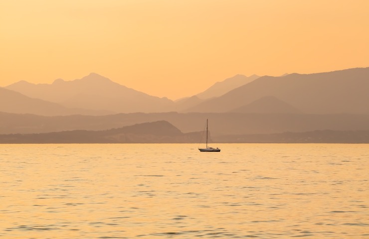 Barca in mezzo al Lago di Garda al tramonto