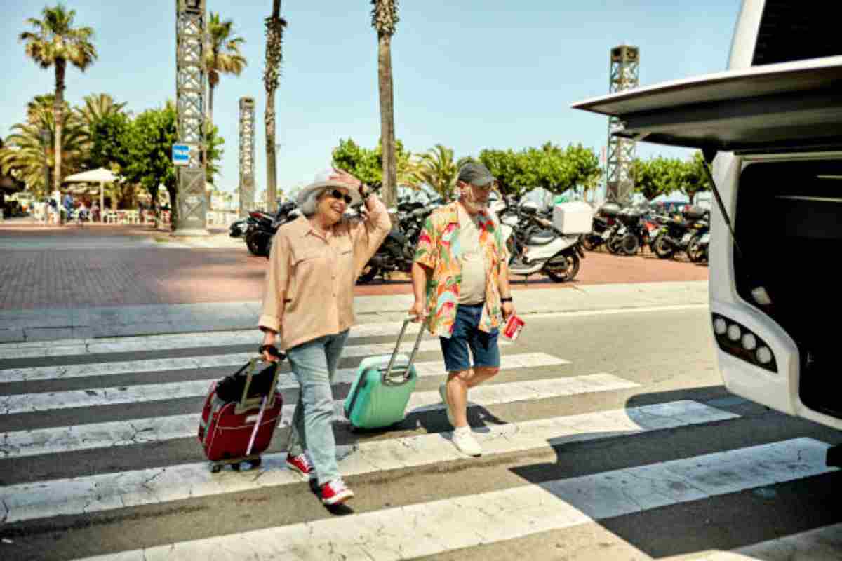 Coppia di anziani in partenza con la valigia