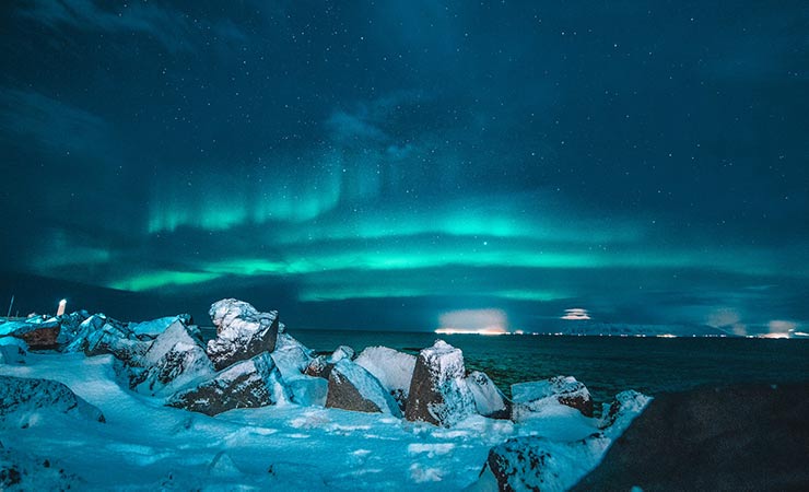 aurora boreale azzurra con ghiaccio e mare