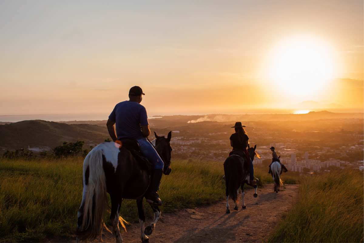 Persone durante una passeggiata a cavallo al tramonto