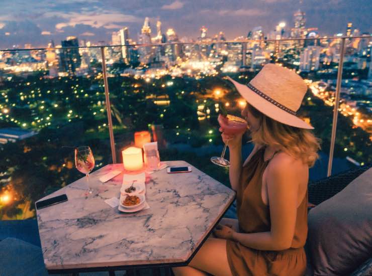 Una ragazza beve un cocktail su una terrazza con vista su Centra lPark