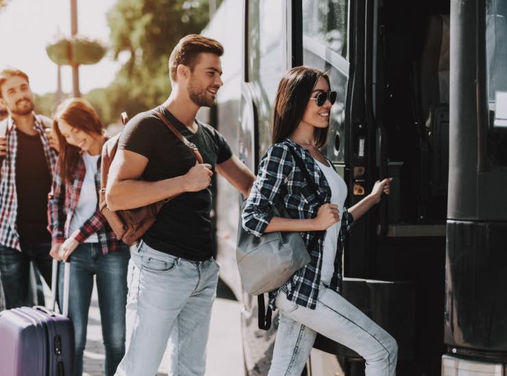 Un gruppo di persone sta salendo su di un pullman