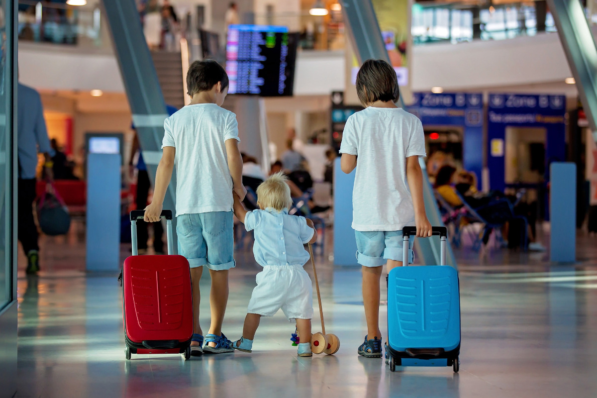 Bambini con la valigia in aeroporto